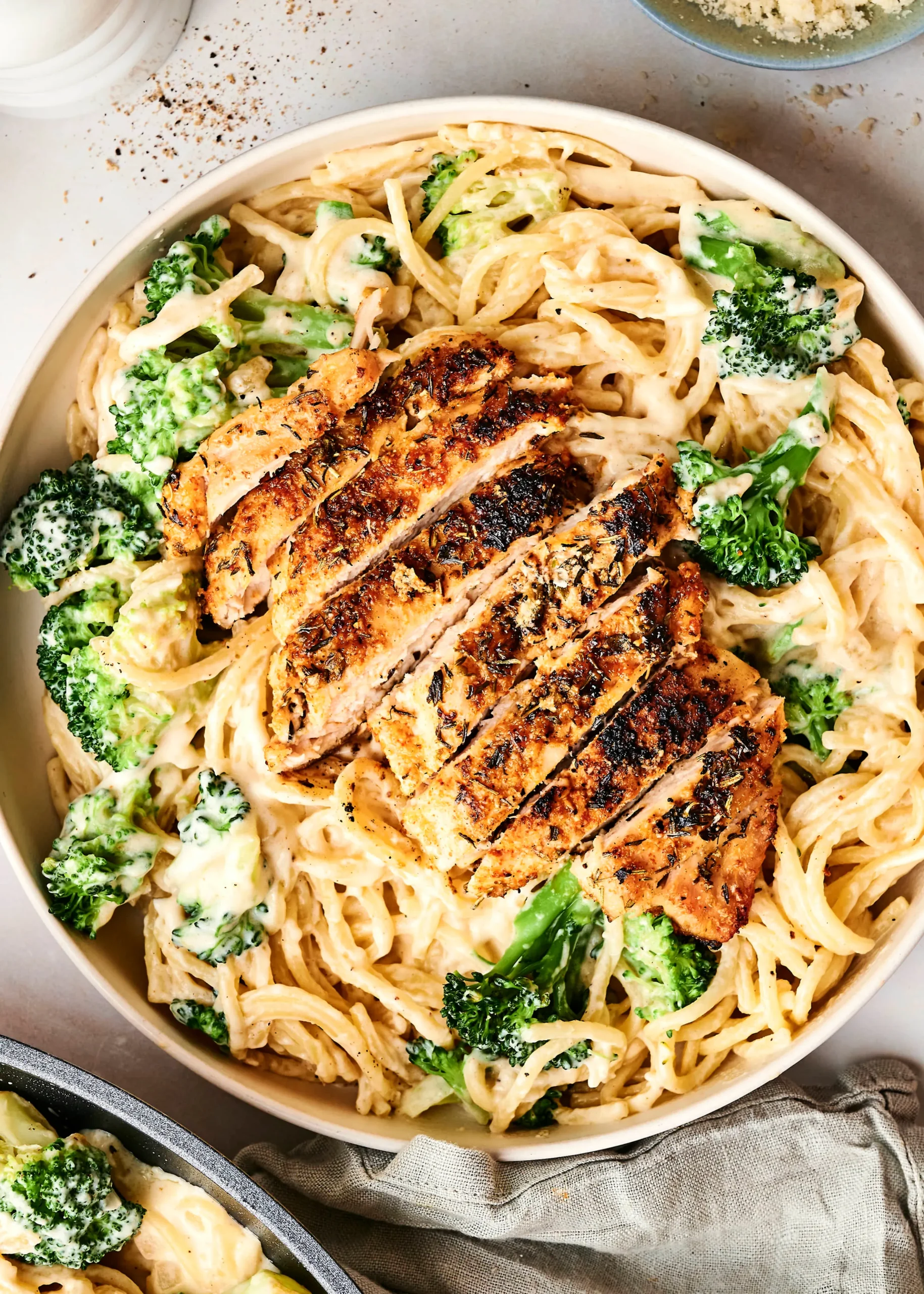 A plate of creamy zucchini noodle chicken alfredo topped with fresh herbs